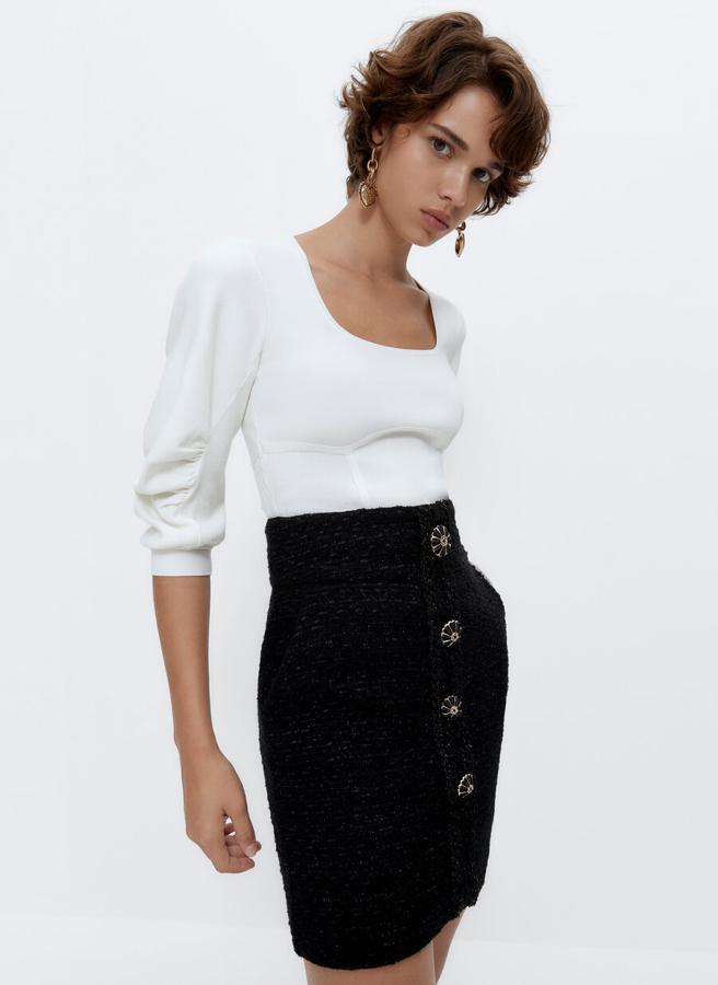 En color blanco, con escote cuadrado y mangas tres cuartos con detalles fruncidos, este bonito jersey de punto de diseño ajustado y acabados en rib está disponible en las tallas S, M y L por 69 euros. 