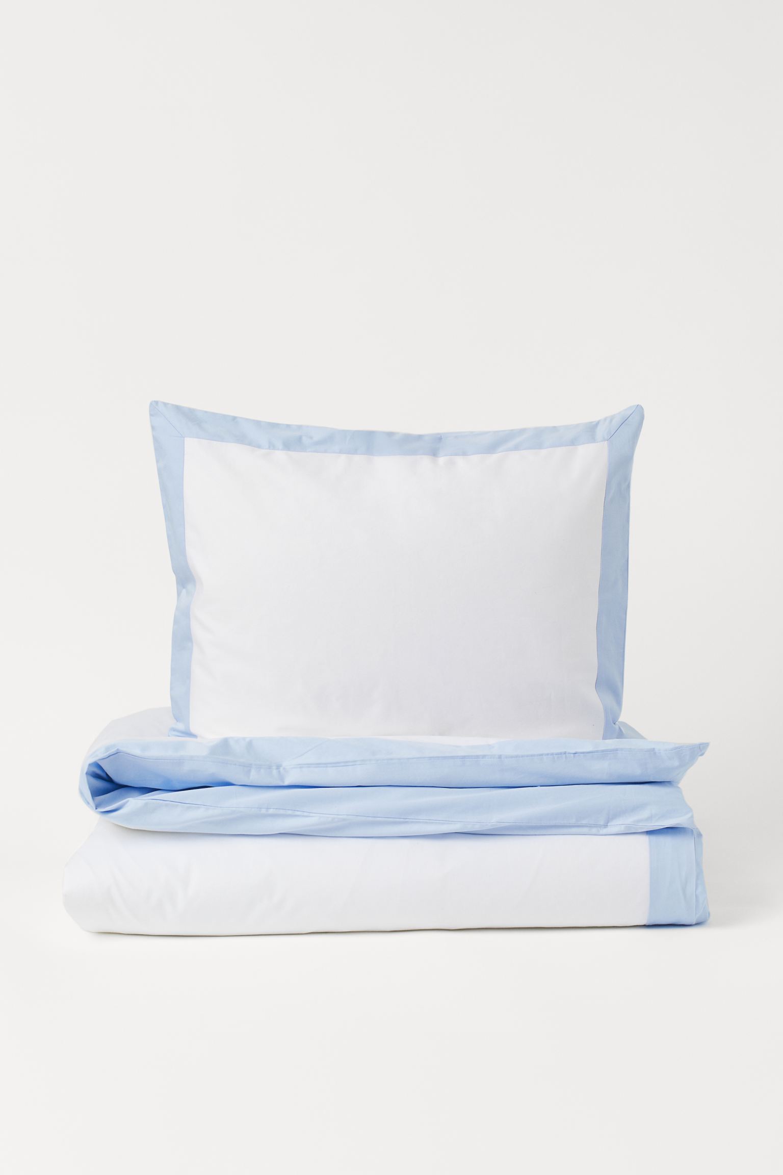 Elegante y minimalista, este juego de sábanas blanco con detalle azul está rebajado a 39.99 euros en H&M Home.