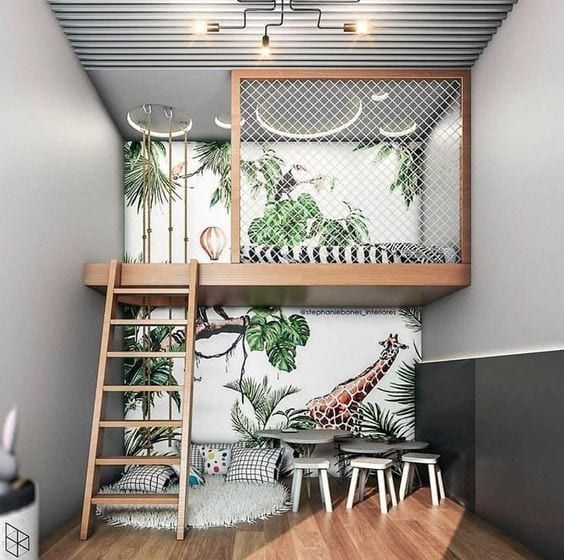 La selva llega a la habitación de tus hijos, y con esta idea de cama elevada permite crear una zona de juegos en la parte inferior que les encantará a los más pequeños. El papel pintado es la clave de la decoración.