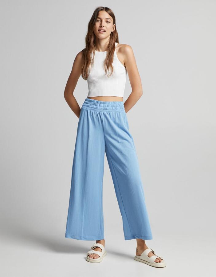 Diseño fluido para este pantalón de Bershka con cintura elástica y perneras anchas que podemos encontrar en azul o en negro y cuesta 19,99 euros. Está disponible entre las tallas XS y XL. 