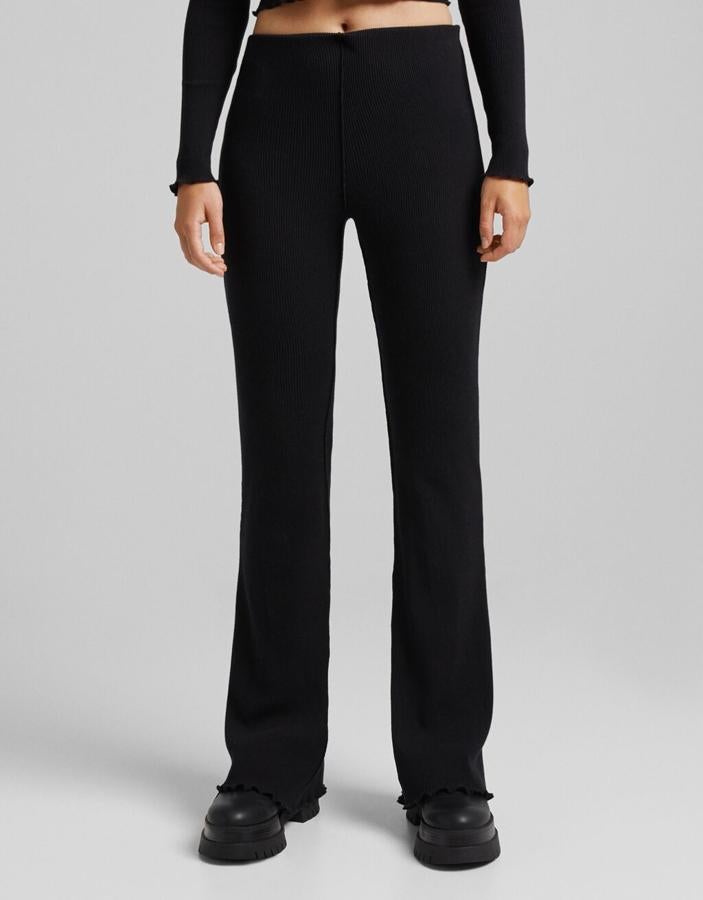 Disponible en negro o en blanco, este pantalón de Bershka con bajos curly y diseño acanalado cuesta 19,99 euros y podemos encontrarlo entre las tallas XS y XL.