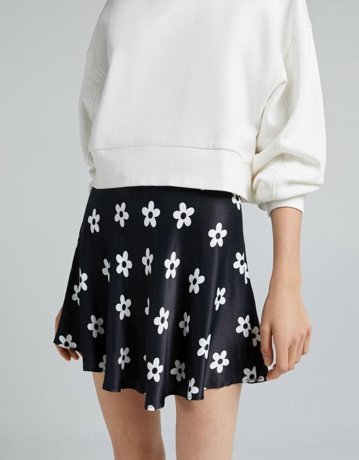 Diseño satinado para esta minifalda de Bershka que podemos encontrar en negro con estampado de flores a contraste o en estampado psicodélico en negro y blanco. La falda tiene vuelo, cuesta 15,99 euros y podemos encontrarlas entre las tallas XS y XL.