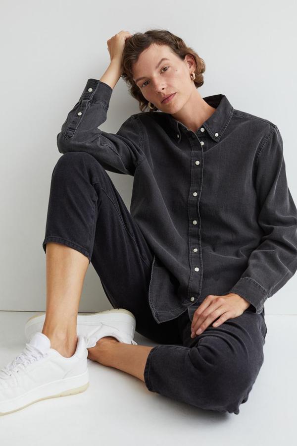Si lo tuyo son los vaqueros negros también puedes apostar por un total look tonal con esta camisa denim en gris oscuro de H&M con cuello americano, cierre de botones frontal y canesú con trabilla en la espalda. De mangas largas con puños sencillos y bajo redondeado, tiene un precio de 24,99 euros y está disponible entre las tallas XS y XXL.