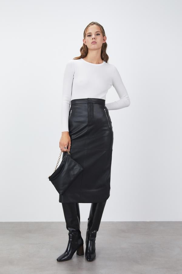 De tiro alto y diseño lápiz, esta falda negra con bolsillos laterales y trasero con cremallera y pespuntes vistos tiene el bajo con abertura trasera y un precio de 35,99 euros. Está disponible en las tallas S, M y L. 