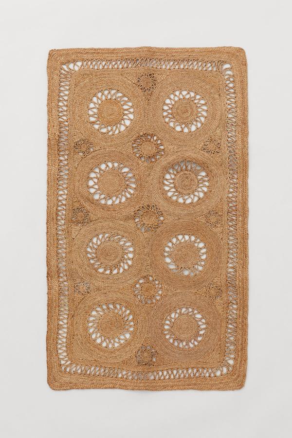 Confeccionada en 100% yute de color natural, esta alfombra con diseño trenzado tiene un precio de 80x140 centímetros y un precio de 79,99 euros.