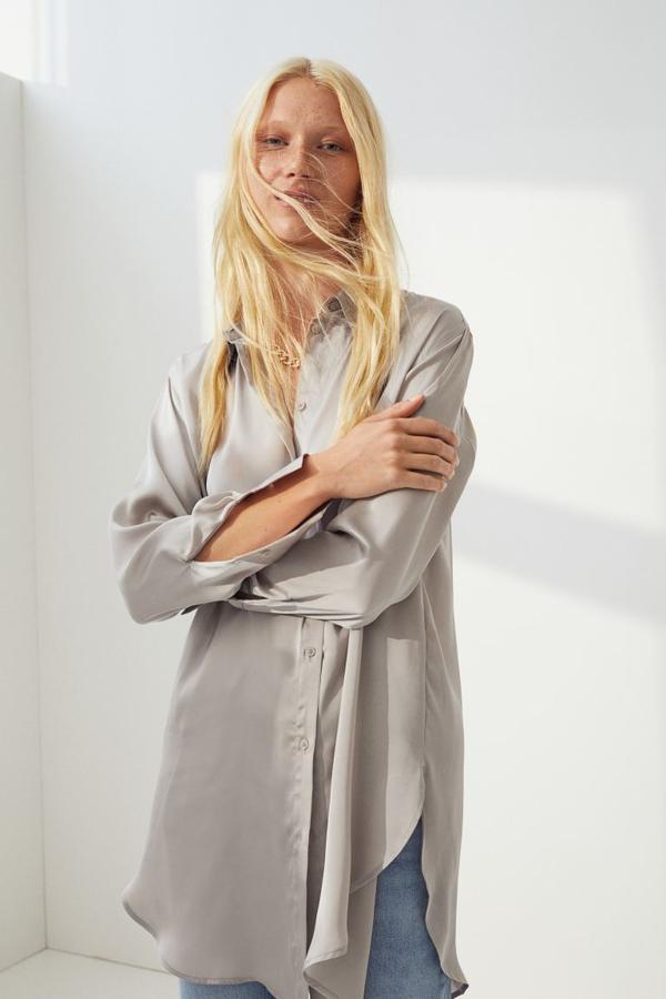 De venta exclusiva en la web de H&M y disponible en azul, blanco y beige grisáceo, esta camisa de satén con suave caída es de cuello clásico, cierre de botones frontal y diseño de hombros caídos. Con bajo redondeado con abertura lateral, cuesta 19,99 euros. 