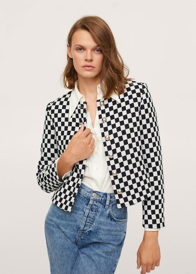 De diseño cropped recto y confeccionada en tejido de mezcla de algodón, esta chaqueta con textura y estampado de cuadros en blanco y negro tiene cierre de botones metalizados en el frontal, cuello redondón y mangas largas. Cuesta 59,99 euros y está disponible entre las tallas XS y XL.