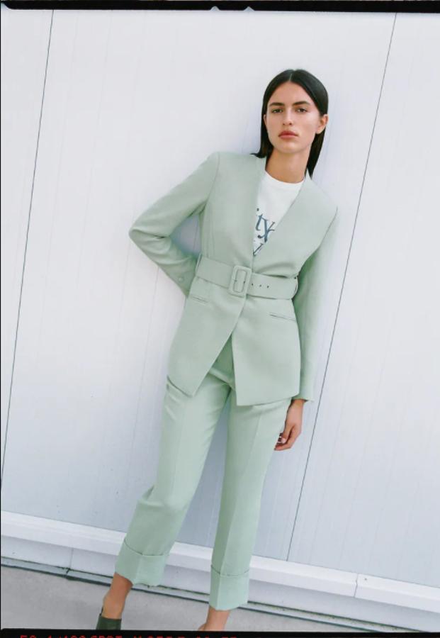 Sin solapa en el cuello, con hombros marcados y mangas largas, esta blazer en verde claro con cinturón con hebilla forrada a tono es de Zara y tiene de cierre frontal de botón a presión. Podemos encontrarla entre las tallas XS y XL y cuesta 49,95 euros. 