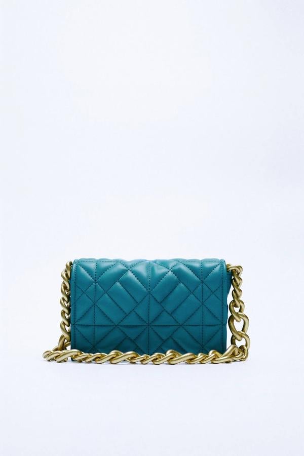 Bolso de hombro acolchado con asa de cadena dorada, en azul. 22,95 euros.