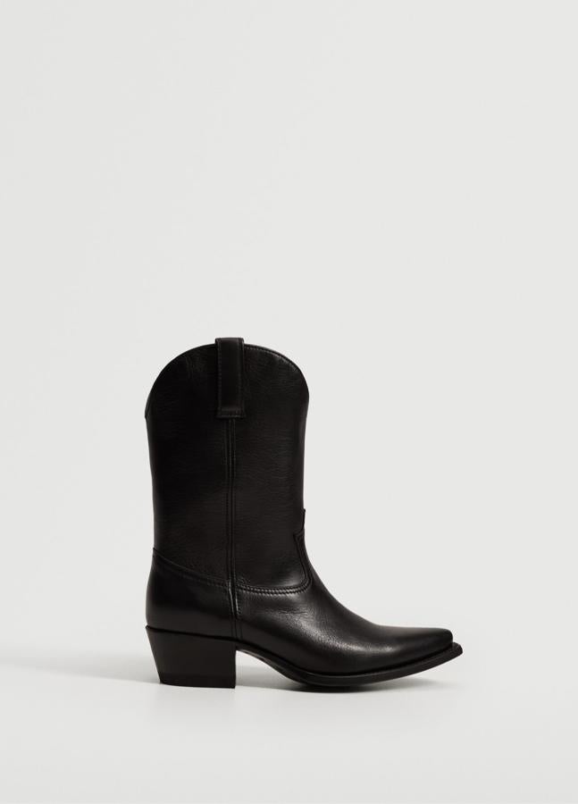 Fabricado en 100% piel de color negro, este botín de estilo cowboy con punta y caña alta cuenta con tacón bloque de 4,5 centímetros y forro interior. Es de Mango y tiene un precio de 249,99 euros.