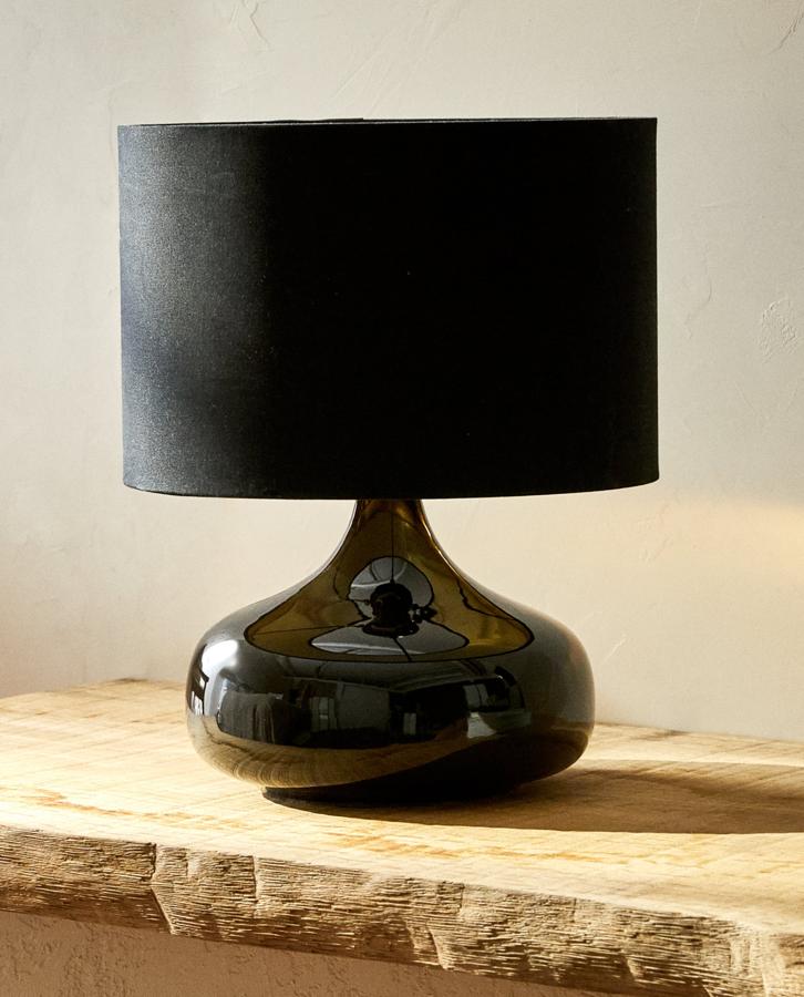 Disponible en negro o en crudo, esta lámpara de mesa de cerámica con interior de la pantalla de color dorado tiene un precio de 49,99 euros.