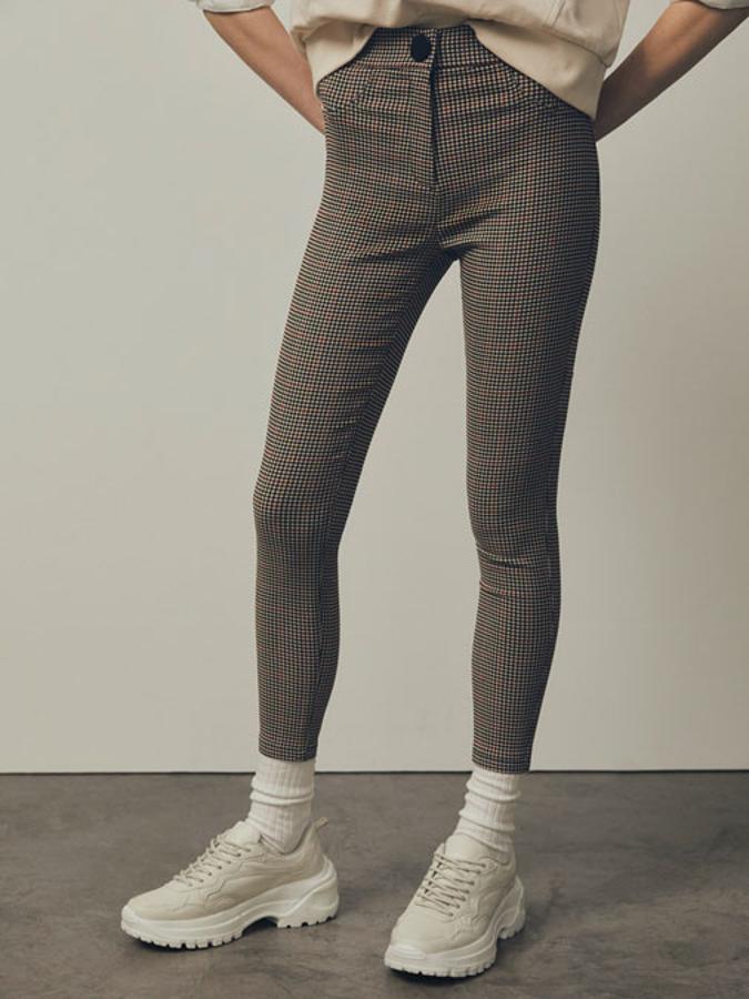 Con estampado de cuadros y disponible en dos colores, estos pantalones tipo jeggins de tiro medio y largo tobillero se ajustan perfectamente al cuerpo y tienen un precio de 14,99 euros,