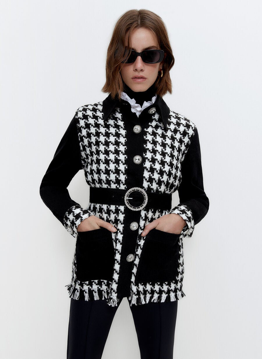 Elegantísima, sofisticada y perfecta para nuestros looks de entretiempo más especiales, esta chaqueta con estampado pata de gallo y cinturón y botones joya de Uterqüe cuesta 129 euros.