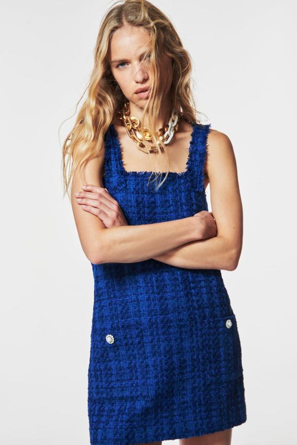 Tweed y más tweed por todas partes. El otoño siempre rescata este elegante tejido y cada temporada te ofrece nuevas propuestas. Un mini vestido azul con botones perla es la última idea de Zara. (39,99 euros)