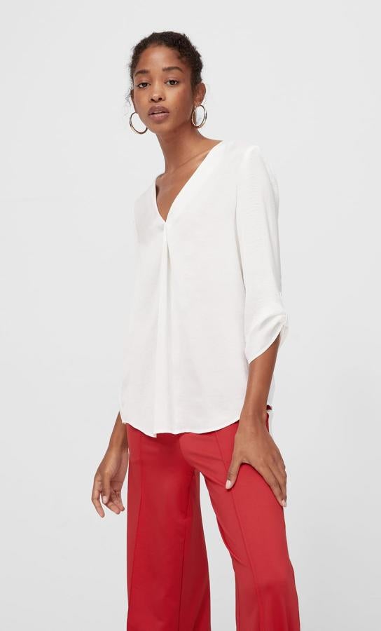 Esta camisa fluida de color blanco con escote de pico y manga tres cuartos es de Stradivarius y tiene un precio de 17,99 euros.