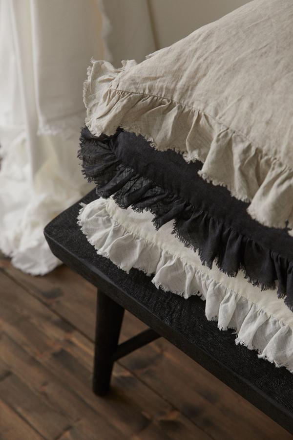 Disponible en varios colores, esta funda de cojín de lino con ribete de volante sin rematar mide 50x50 centímetros y tiene un precio de 14,99 euros.