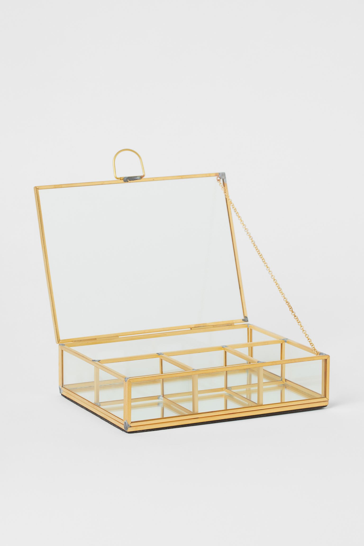 Una versión más barata pero muy decorativa la encontramos en H&M Home, donde este joyero con acabado metalizado cuesta 17.99 euros.