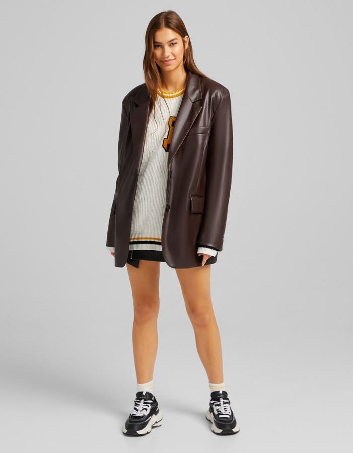 En efecto piel en color marrón o en negro, esta blazer de Bershka con hombros marcados, bolsillo al bies en la pechera y de solapa en los laterales con diseño ligeramente oversize cuesta 29,99 euros y está disponible entre las tallas XS y L. 