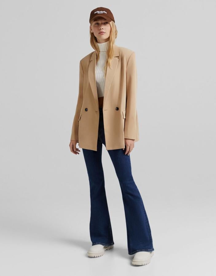 Disponible en cinco colores diferentes, entre ellos el camel, el rosa o el verde agua, esta blazer fluida de Bershka con cuello de solapa con muesca, bolsillos laterales de solapa y cierre de botón frontal cruzado tiene un precio de 29,99 euros y podemos encontrarla entre las tallas XS y L. 