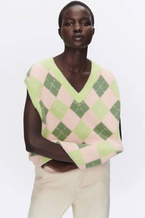 El más clásico es de Zara. Tiene un diseño de rombos, un escote amplio en forma de pico y manga sisa. En cuanto a su precio, es de 25,95 €.