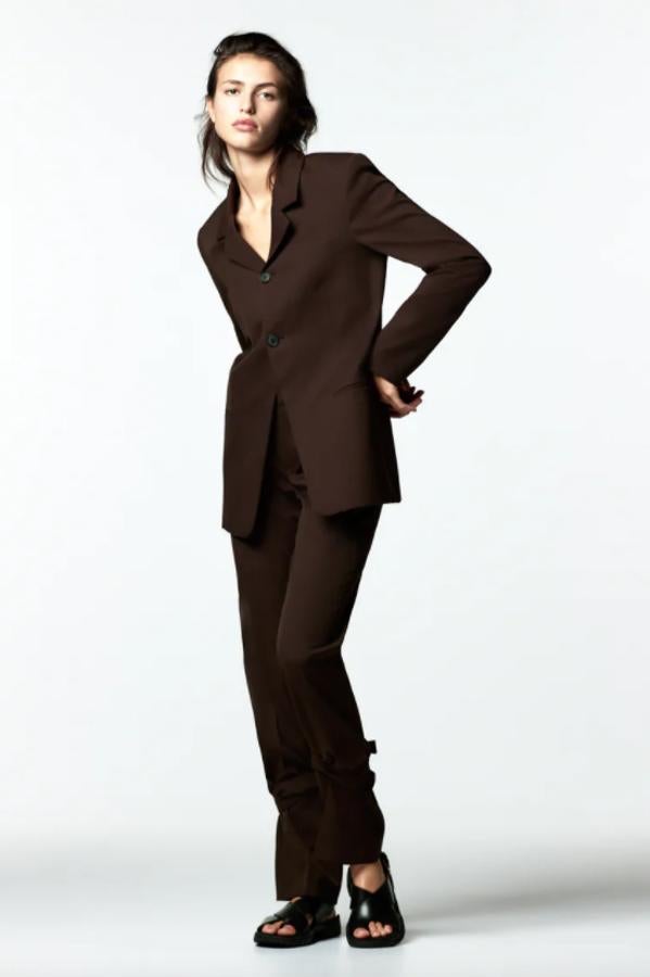 De tiro medio y con bolsillos laterales, este pantalón marrón de Zara viene con perneras rectas y detalle de bajo ajustable con cinta en mismo tejido y hebillas. Con un precio de 49,95 euros, está disponible entre las tallas XS y XXL. 