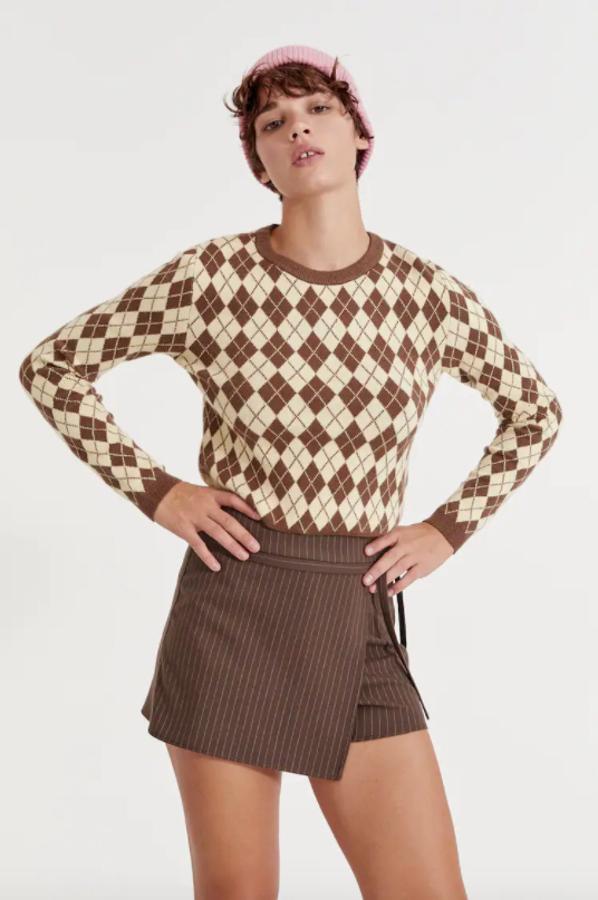 Disponible en color vainilla con rombos marrones o en dos tonos de azul, este jersey cropped de Pull&Bear con cuello redondo y acabados en rib cuesta 19,99 euros y está disponible entre las tallas XS y L. 