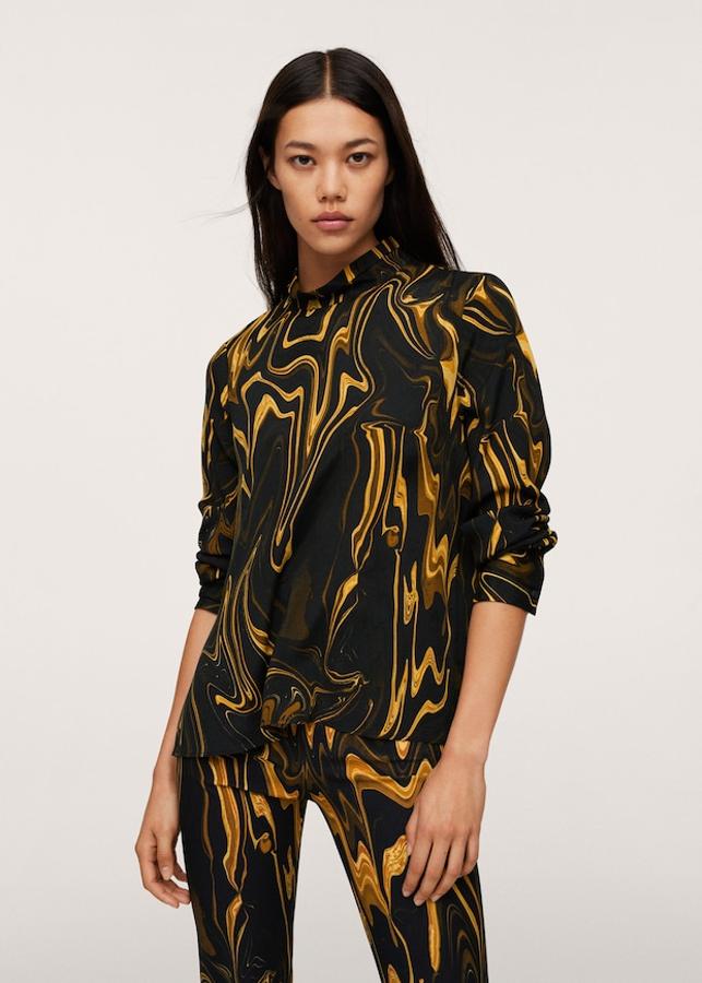 Diseño marmoleado en tonos mostaza sobre negro para esta blusa de diseño recto y cuello perkins con mangas largas acabadas en puños abotonados. Con un precio de 25,99 euros, podemos encontrarla entre las tallas XS y XL. 