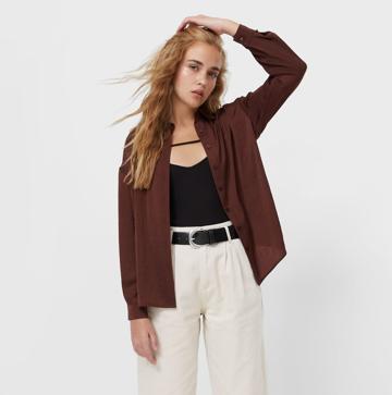 Imagen secundaria 1 - La camisa de satén marrón que cuesta menos de 20 euros y rejuvenece a los 50 es el comodín que soluciona todos tus looks de entretiempo