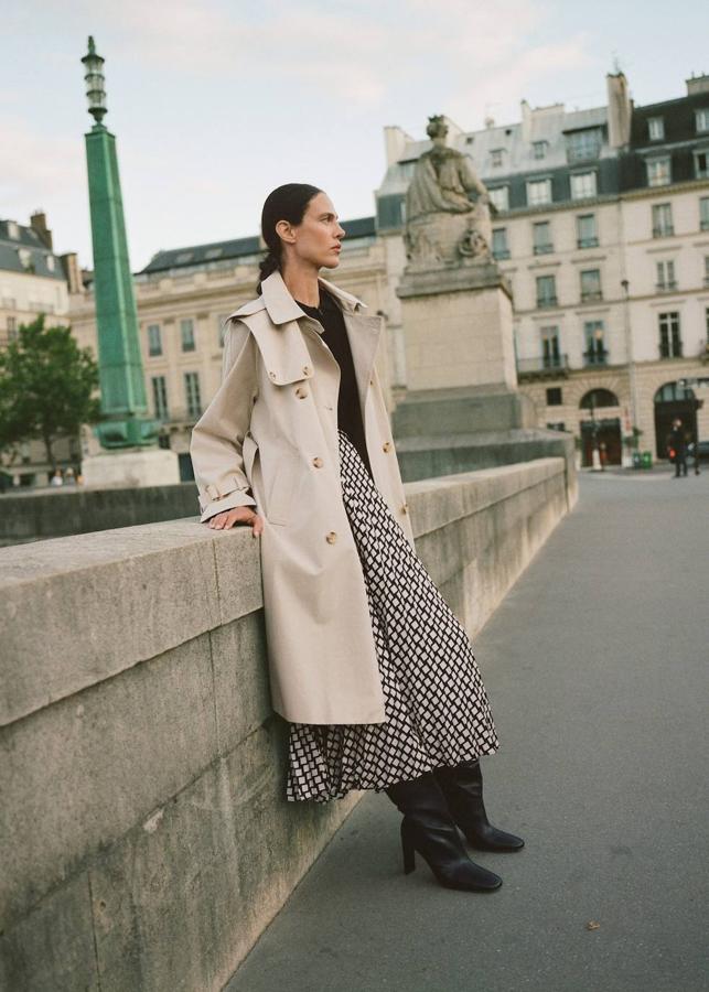 Falda midi plisada con estampado geométrico, 39,99 euros. Gabardina con capucha desmontable, 99,99 euros. Jersey de canalé negro con cremallera y cuello camisa, 19,99 euros. Botas de piel altas con tacón, 129,99 euros.