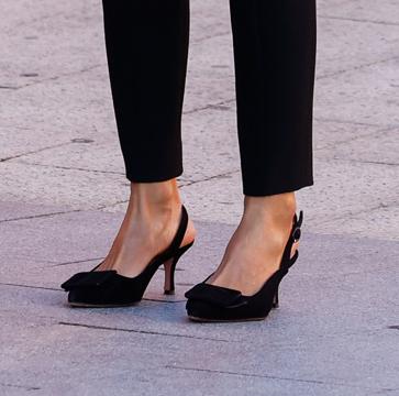 Imagen secundaria 1 - La Reina, con blusa romántica y pantalones negros de Uterqüe, y salones de tacón cómodo de Isabel Abdo.