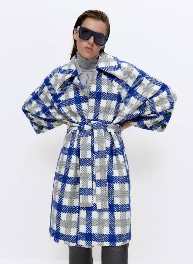 Abrigo de lana con cinturón, estampado de cuadros y adornos de botones joya en las mangas, de Uterqüe. 229 euros