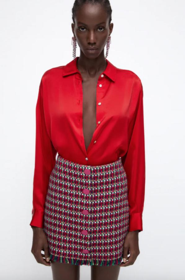 Estampado geométrico en rojo, blanco y verde para esta falda mini de tiro alto con acabado desflecado y detalle de falsos botones de color rojo en el frontal. Cuesta 25,95 euros, pero solo queda en la talla XS. 