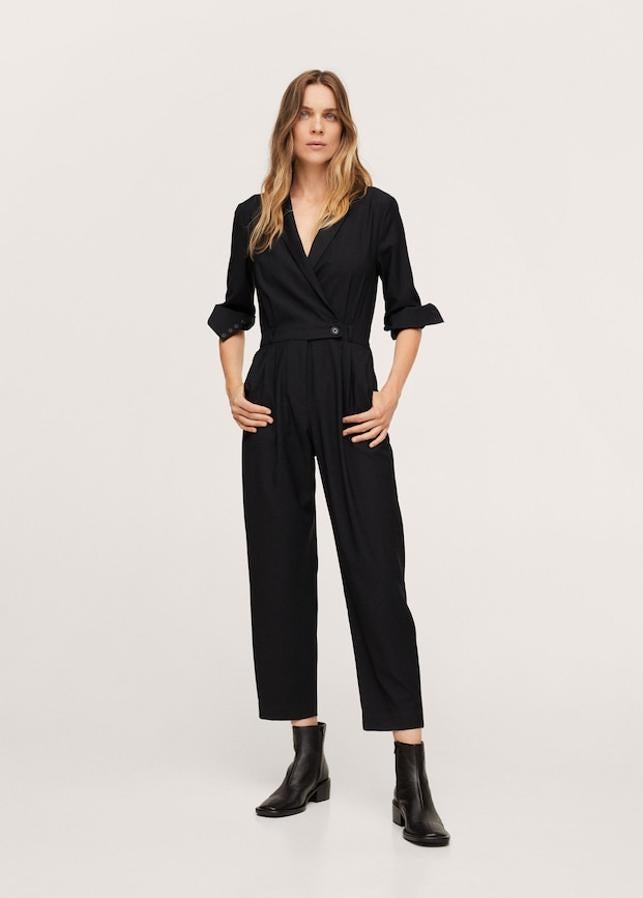 En color negro, de diseño recto y largo, este mono de Mango con escote de pico cruzado y solapas con muesca. Con mangas largas con puños abotonados y dos bolsillos laterales, viene con detalle de pinzas y bolsillo de ribete en la parte superior y cierre oculto de botón, gancho y cremallera. En la web solo queda en la talla XXS por 49,99 euros. 