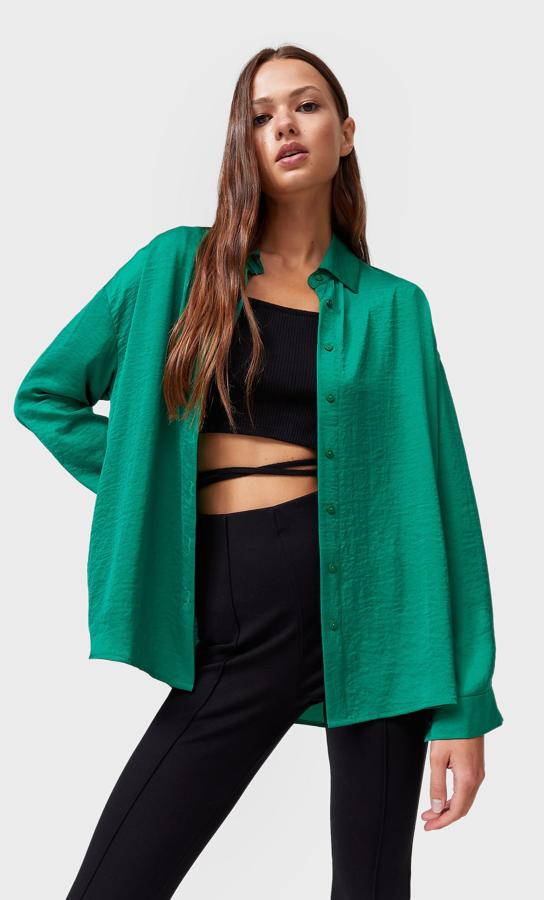 En satén, con mangas largas y cuello de solapa, esta camisa de Stradivarius en color verde con cierre frontal de botones a tono cuesta 19,99 euros y está disponible entre las tallas XS y L.