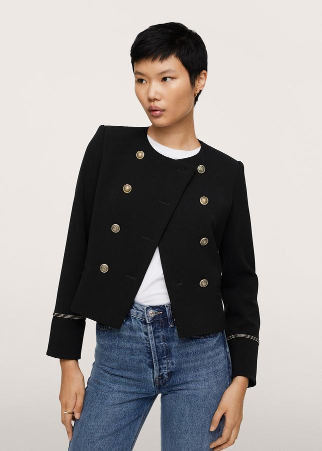 Y para los estilos más conservadores también tiene otra interesante propuesta Mango. Una chaqueta de aires militares de color negro y con doble botonadura en color plata. Chaqueta corta de Mango (59,99 euros). 