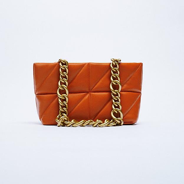 Imagen principal - 1. Bolso de color naranja con asa de cadena dorada de Zara (35,99 euros). 2. Bolso acolchado en color lila de Zara (25,99 euros). 3. Bolso estilo shopping bag con asa corta en color blanco roto de Zara (35,99 euros). 