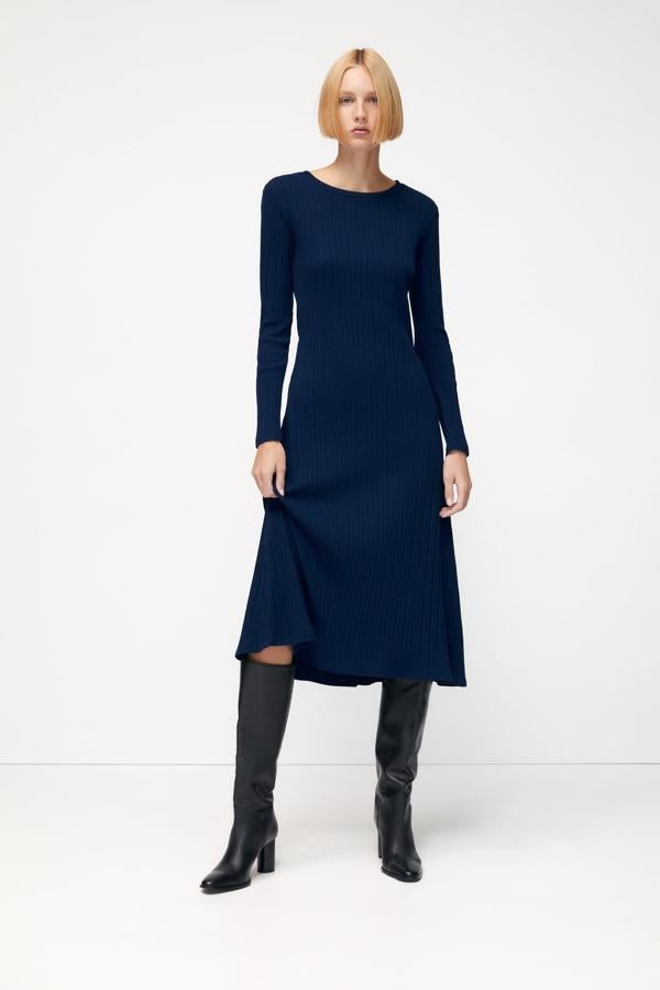 Los vestidos ceden posiciones cuando bajan las temperaturas, pero hay opciones con las que no pasarás frío. Este diseño de canalé con manga larga y largo midi es perfecto para llevar con botas altas. Vestido en color azul oscuro de Zara (19,99 euros)