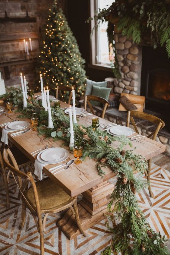 El estilo rústico y la calidez de la madera se unen en un tándem perfecto en esta decoración de boda de invierno. El abeto es el protagonista, tanto en el camino de mesa tan original como en el árbol navideño que preside la estancia. Y esa chimenea...