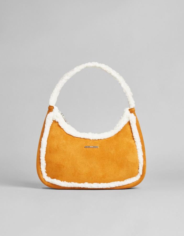 En uno de los tonos de la temporada, el mostaza, con cuerpo en efecto ante y detalles y asa de mano en borrego blanco, este bolso tiene un precio de 17,99 euros. 