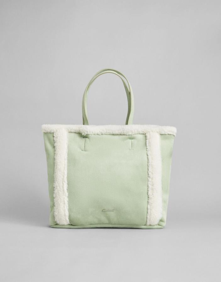 Verde agua y diseño shopper para este bolso con asa a tono y detalles de borrego blanco en el cuerpo y la parte superior. Cuesta 25,99 euros.