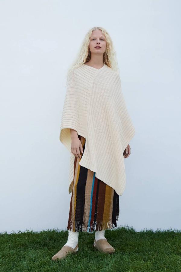 Capa larga asimétrica de punto en tono crudo de Zara. 39,95 euros