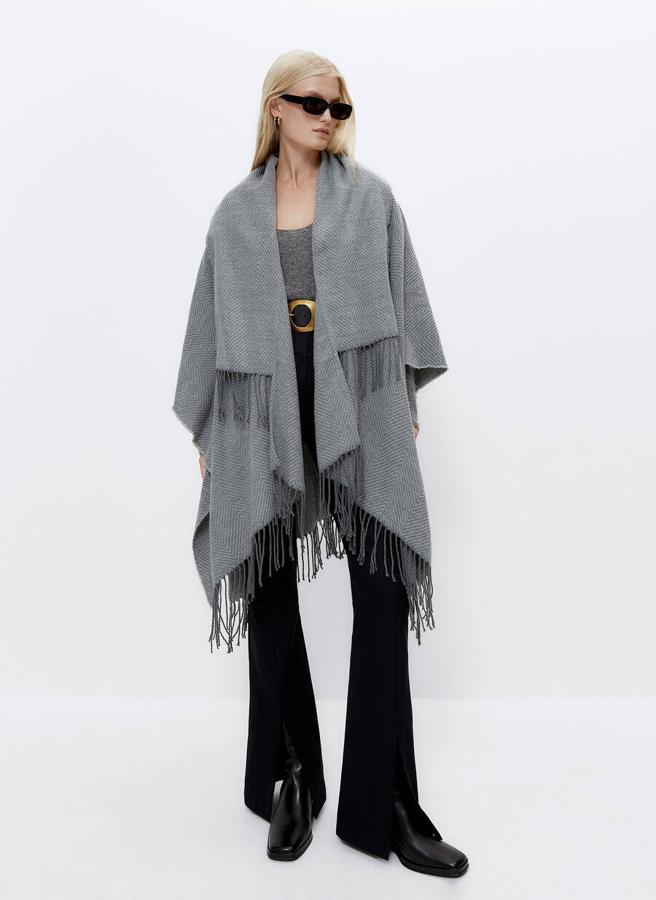 Poncho largo cálido con solapas y flecos en gris de Uterqüe.