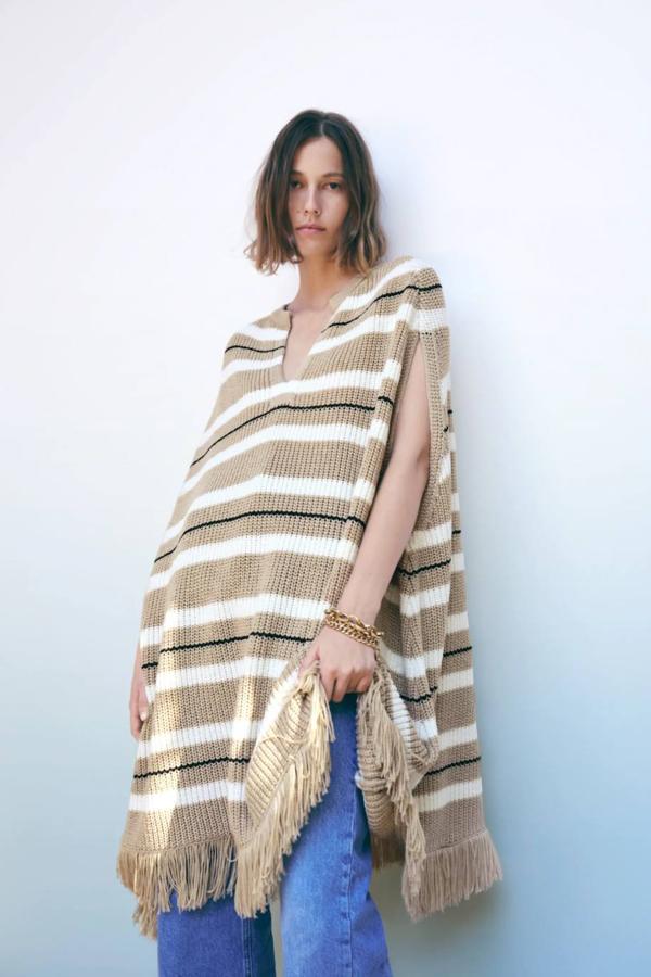 Poncho de punto a rayas con bajo acabado en flecos de Zara. 49,95 euros