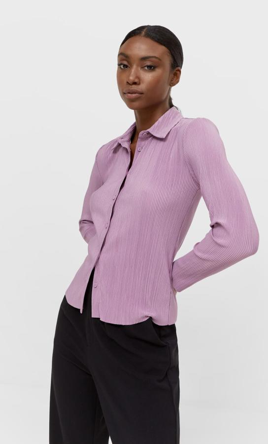 Disponible en nueve colores, entre ellos el verde botella, el turquesa o el lila, esta camisa plisada de Stradivarius con cuello de solapa y manga larga viene con cierre frontal de botones y cuesta 19,99 euros. Está disponible entre las tallas XS y XL, aunque algunas se han agotado. 