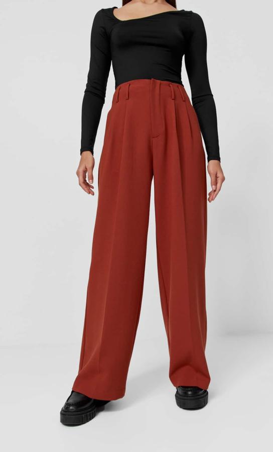 Tiro alto y perneras anchas para estos pantalones con detalle de pinzas delanteras y en color ámbar de Stradivarius que tienen un precio de 25,99 euros y está disponible entre las tallas 32 y 44. 