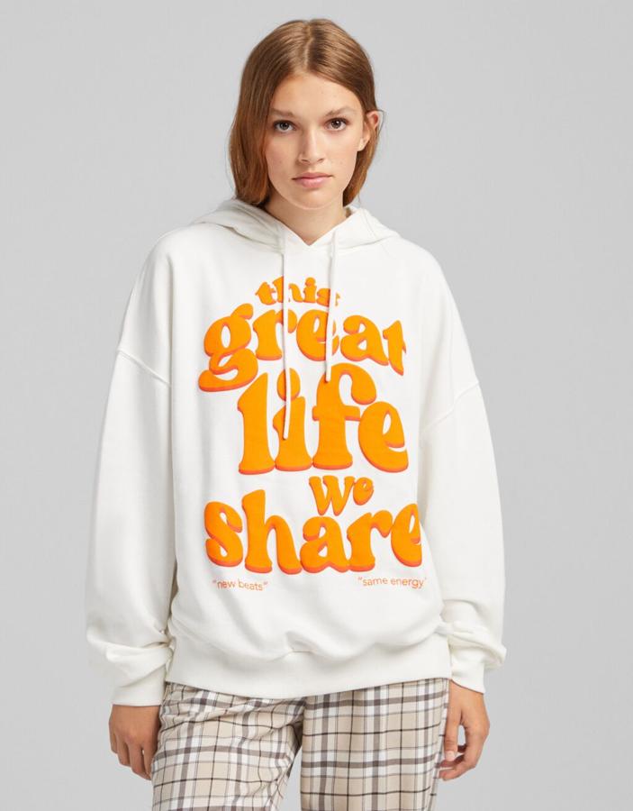Esta sudadera con capucha de Bershka en color blanco y print frontal de letras en color huevo tiene un precio de 25,99 euros y está disponible entre las tallas XS y L. 