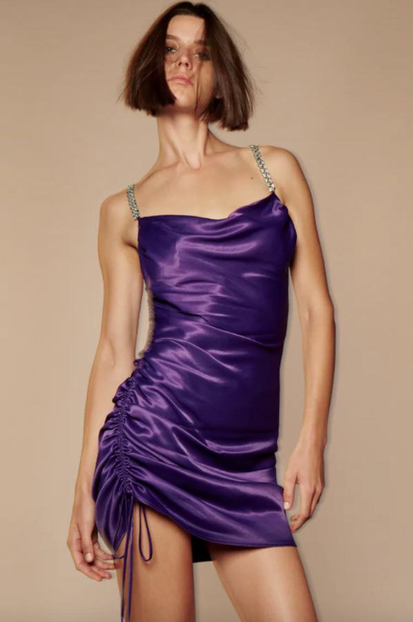 En color morado y tejido satinado, este vestido mini de Zara con cuello fluido y tirantes finos de cadena viene con detalle de frunce ajustable con cordones en un lateral y cuesta 39,95 euros. Podemos encontrarlo entre las tallas XS y XXL. 