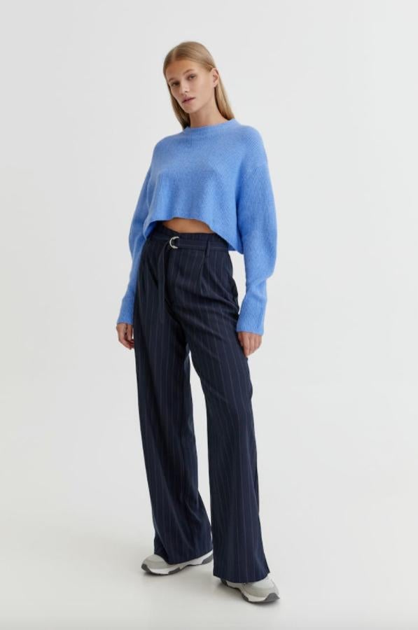 Diseño cropped en punto perlado para este jersey de Pull&Bear disponible en rosa, azul y gris que viene con cuello redondo y detalles en rib y está disponible entre las tallas XS y L. Cuesta 19,99 euros. 