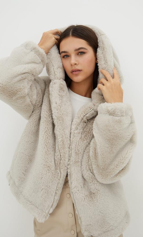 Esta cazadora de pelo con capucha es de Stradivarius y podemos encontrarla en color negro o en piedra. Con cierre frontal de cremallera a tono y bajo ajustable con cordones, cuesta 39,99 euros y está disponible entre las tallas XS y XL. 