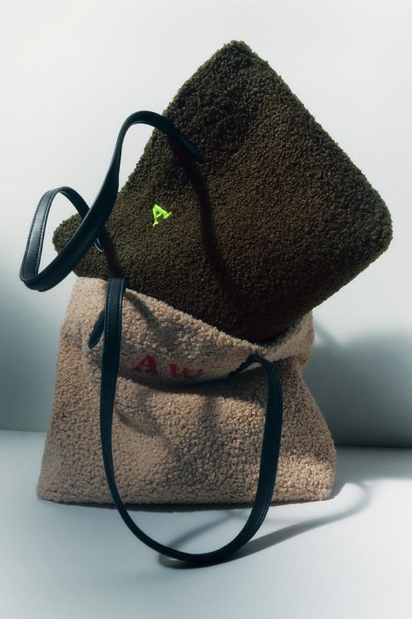 Los bolsos personalizados con inciales se han convertido en lo más vendidos de Zara. La versión de invierno llega cubierta de borreguito en dos tonos, beige o verde bosque. Bolsos shopper bag de Zara (25,99 euros). 